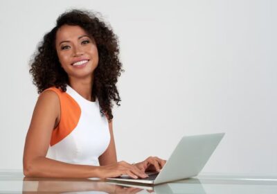 closeup-pretty-woman-ditting-desk-with-laptop-smiling-camera_1098-20804