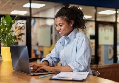 side-view-smiley-woman-working-with-laptop-office_23-2148908808-1